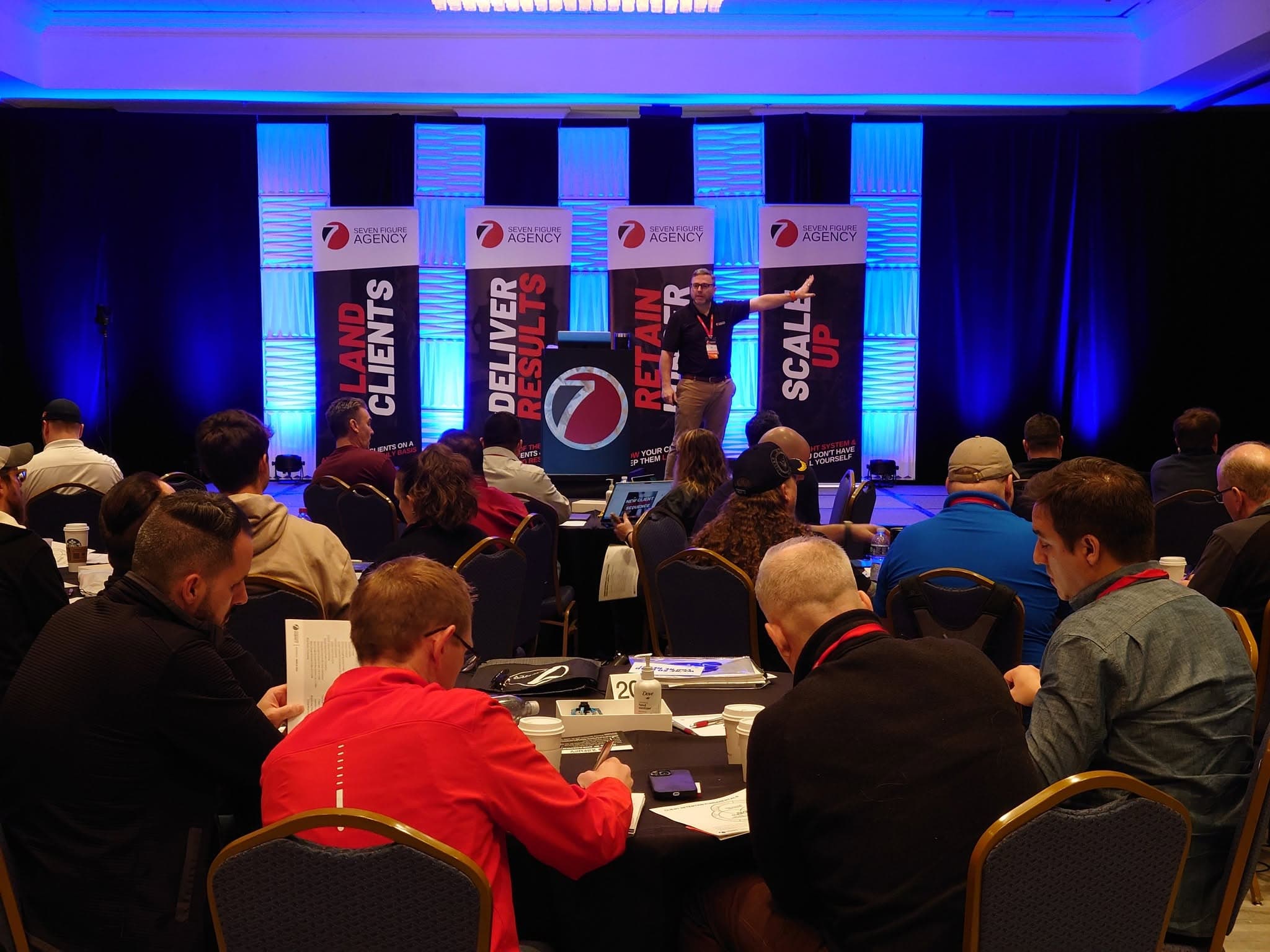 Lyn Askin speaking on stage at a business conference