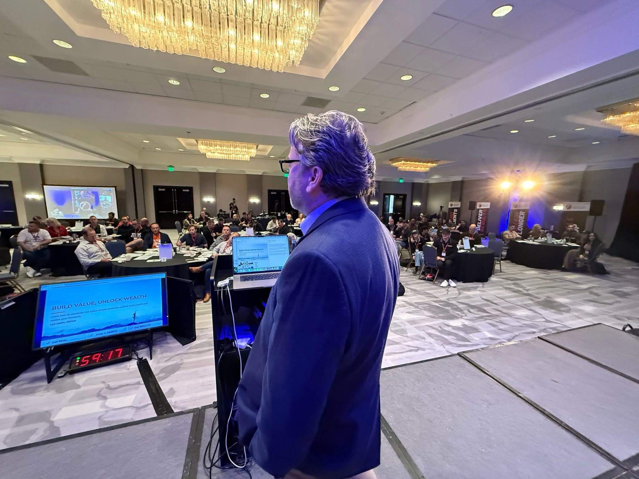 Lyn Askin speaking on stage at a business conference