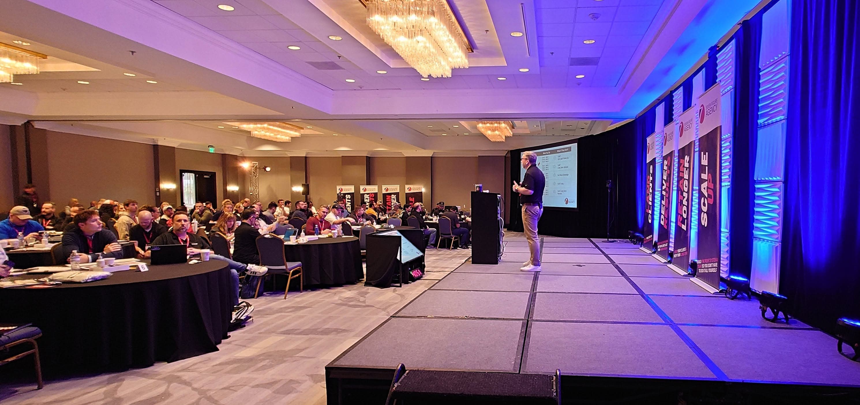 Lyn Askin speaking on stage at a business conference
