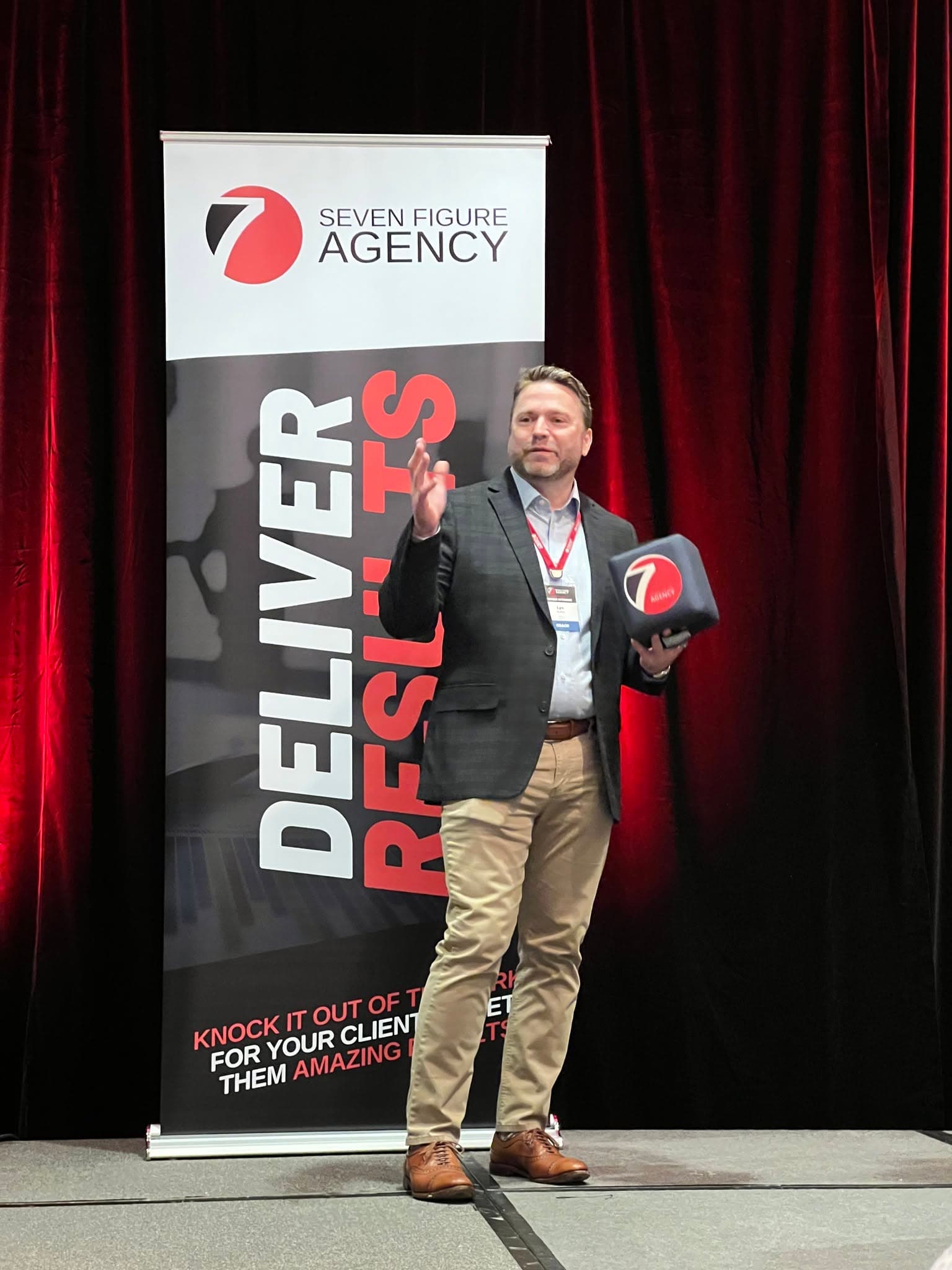 Lyn Askin speaking on stage at a business conference
