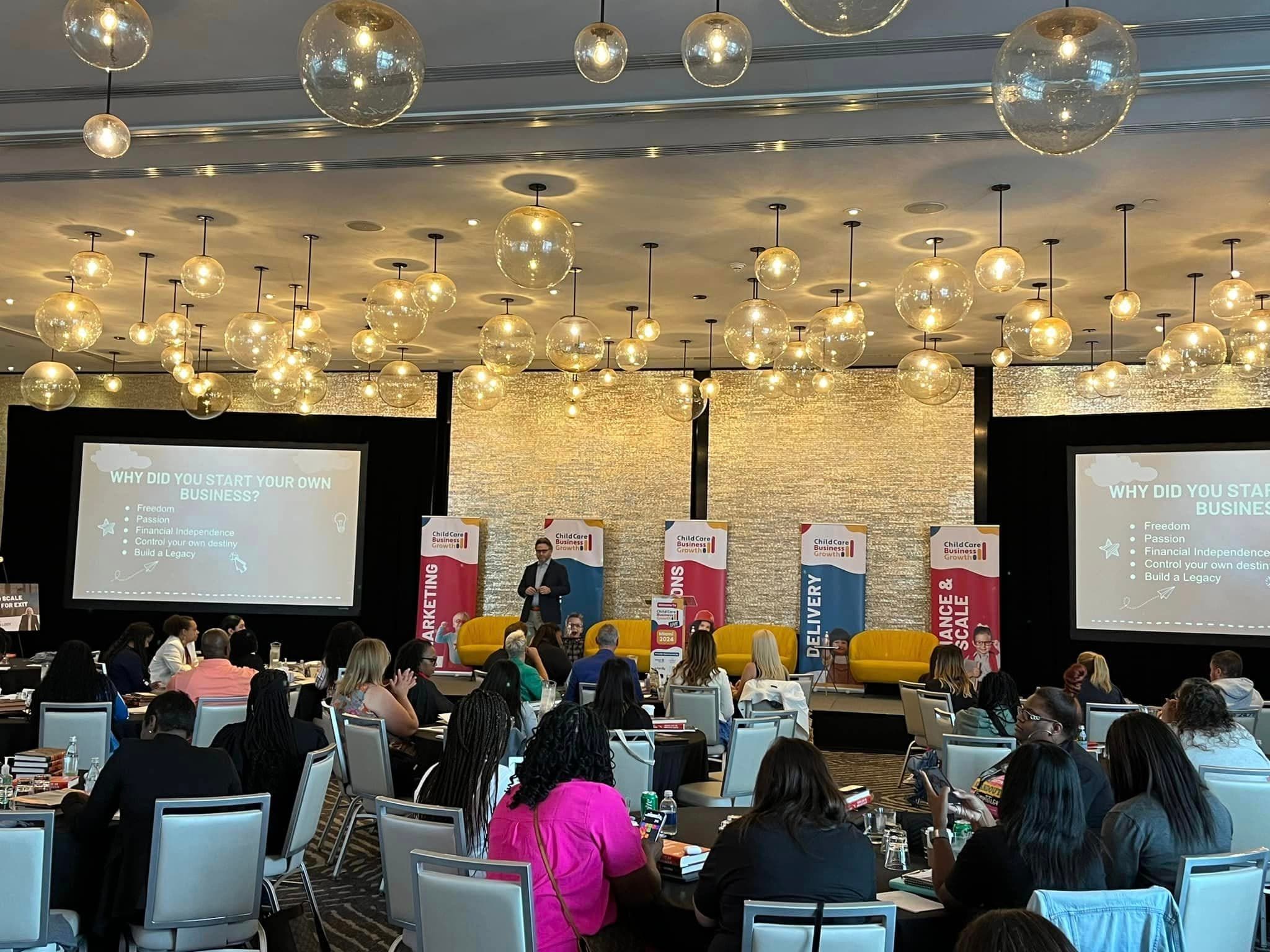 Lyn Askin speaking on stage at a business conference