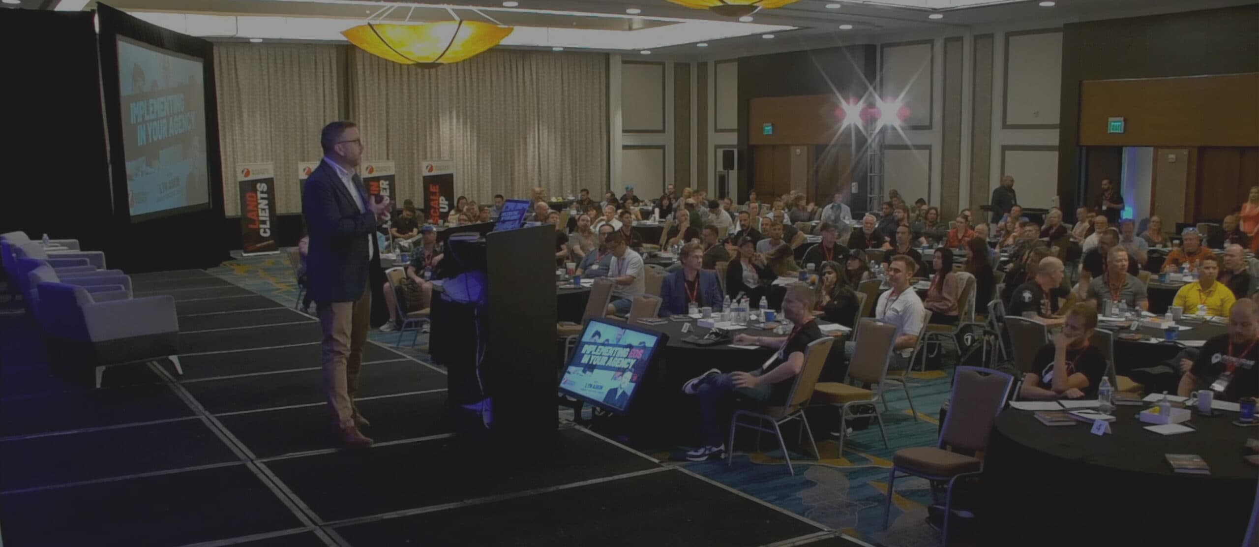 Lyn Askin speaking to a full conference room about implementing EOS in your agency